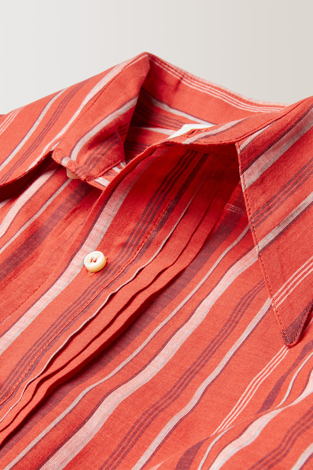 Col Hirondelle | Patte de boutonnage à pli | Coupe ample au dos long | Pli plat au dos | Boutons corne signature | 100% coton, popeline à rayure | Fabriquée en France